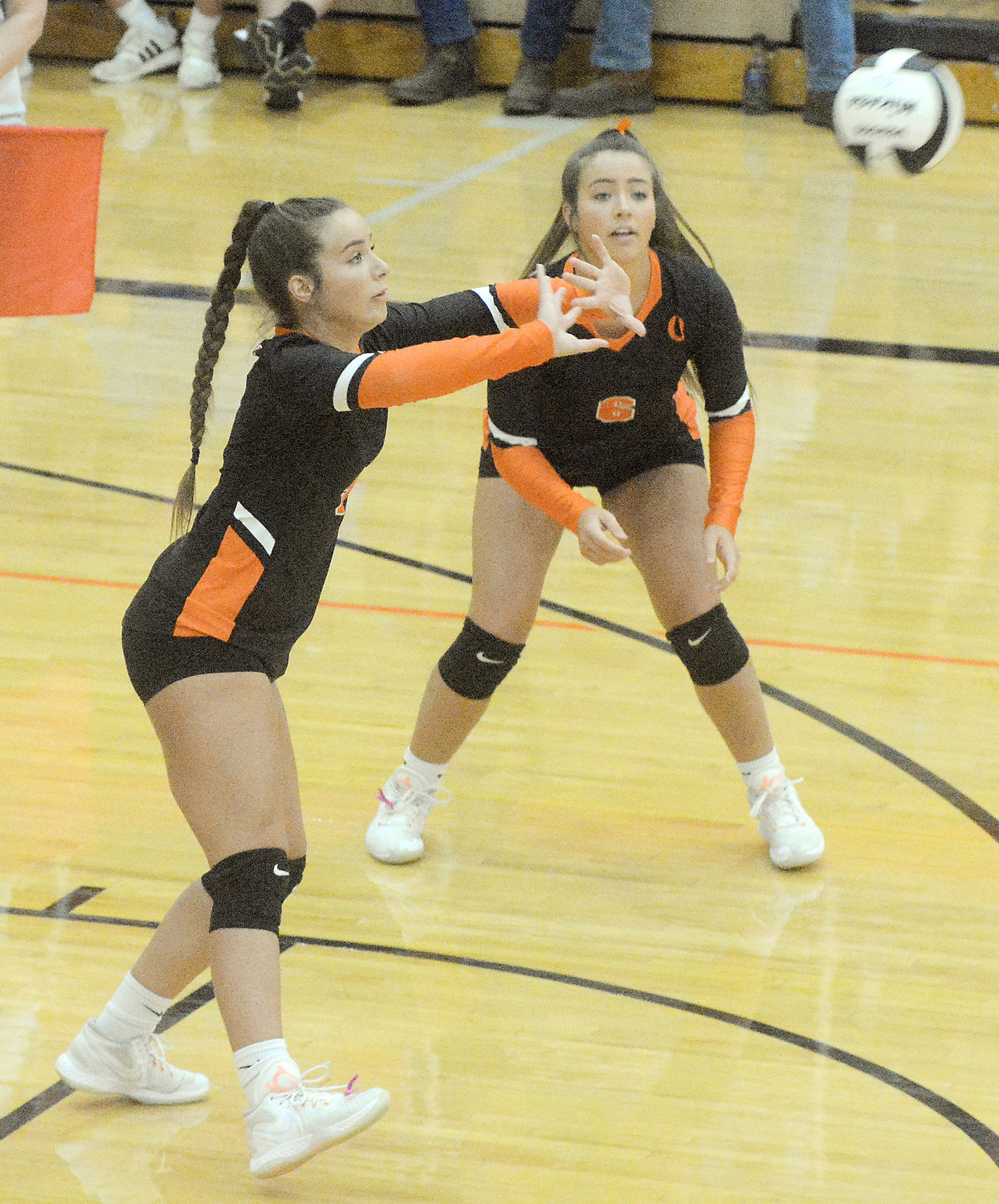 Keira Hendrix (above, left) pushes the volleyball towards the net while her twin sister Kyla Hendrix watches to see where it winds up during varsity action last Thursday against Fatima at Owensville High School.